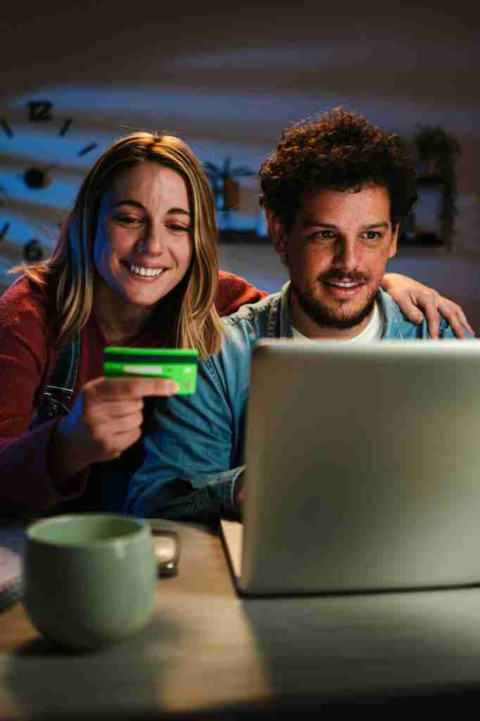 Vertical. Young married couple buying on a marketplace online and paying with credit card together