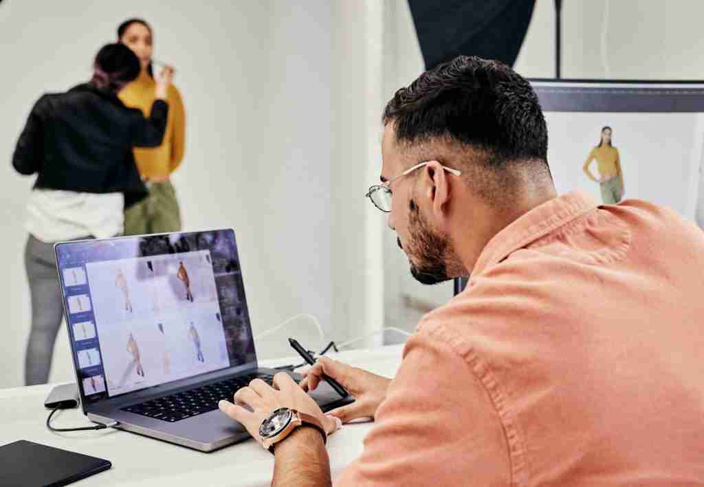 Photographer, laptop and editing photography with man in creative studio and check work with creati