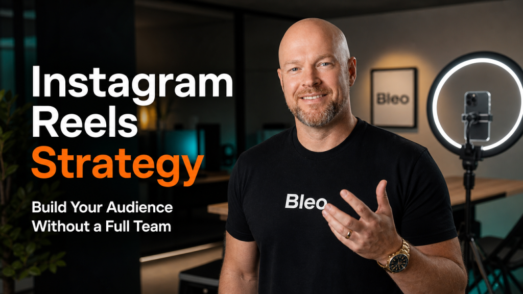 Luke Houlihan in a modern content studio with ring lights, smiling confidently with hand raised, wearing Bleo-branded clothing, with text overlay reading "Instagram Reels Strategy: Build Your Audience Without a Full Team"