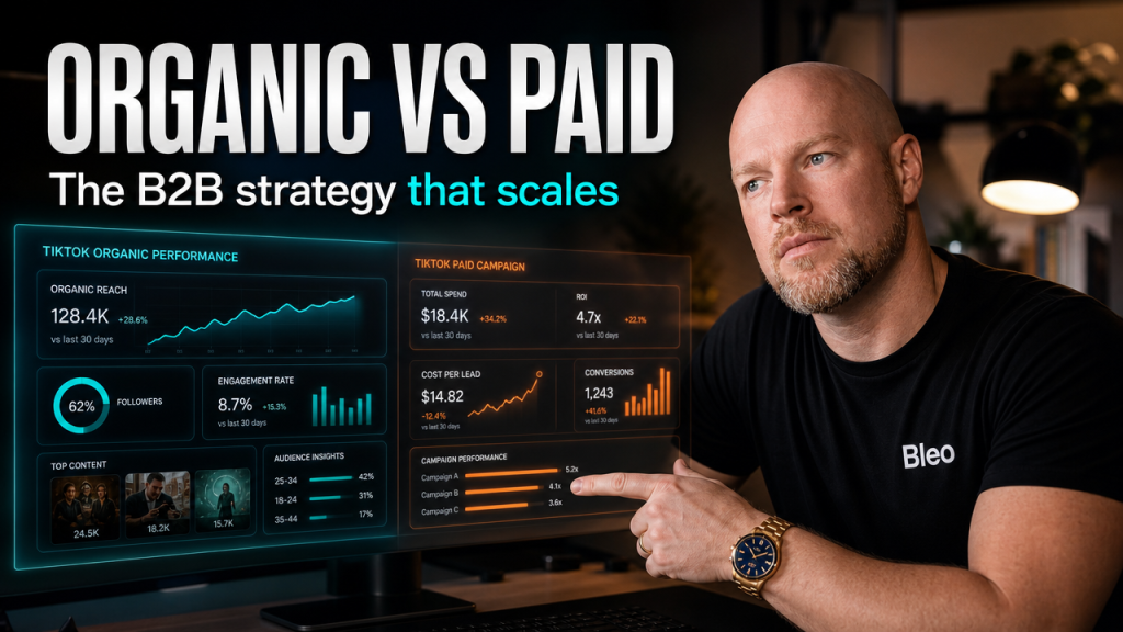 Luke Houlihan examining split-screen TikTok analytics showing organic versus paid campaign metrics on a modern office desk, wearing Bleo-branded clothing